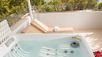 A hot tub with a view of the sea and trees.
