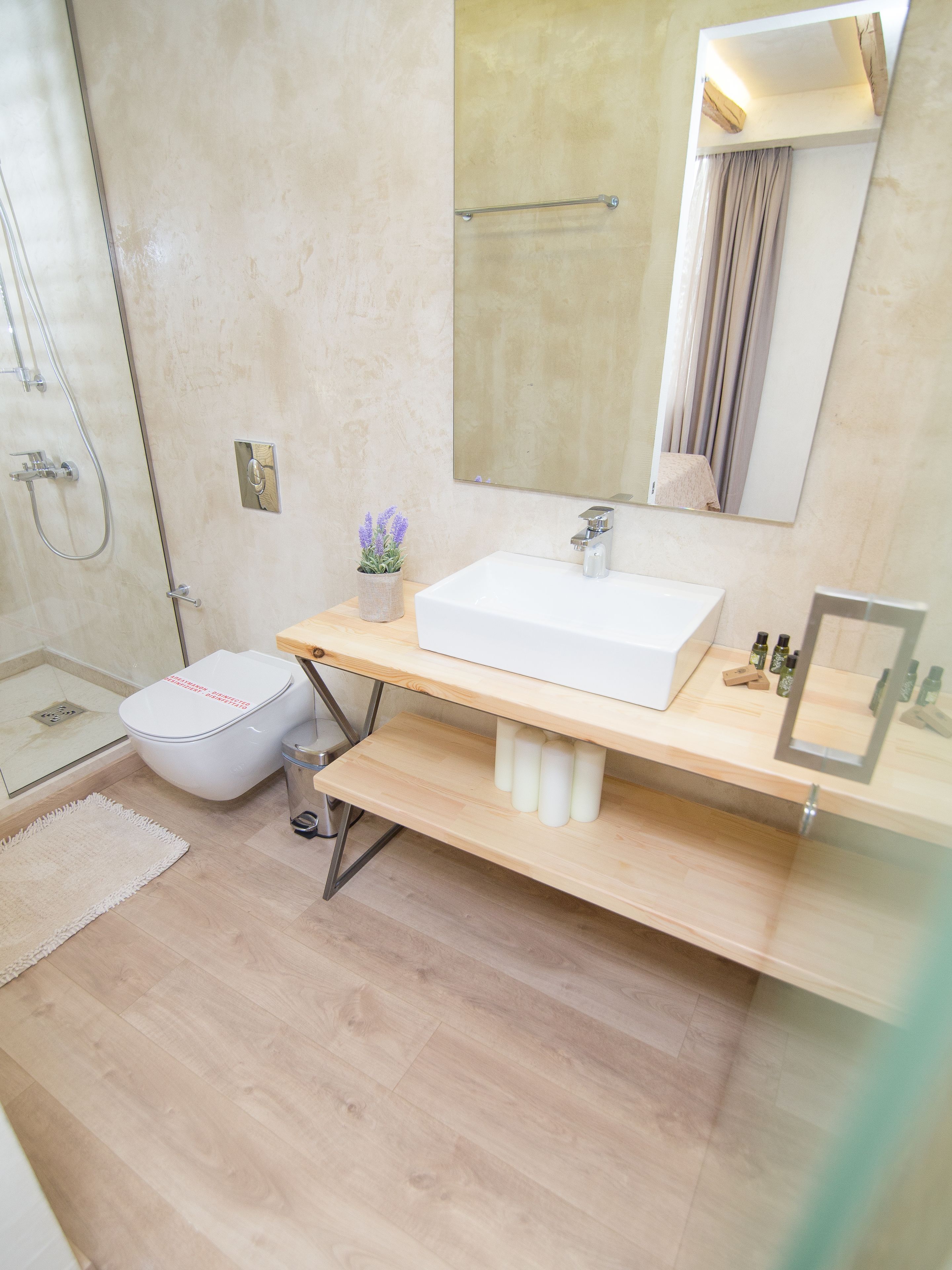 Un baño moderno con un lavamanos blanco, un espejo y una ducha.