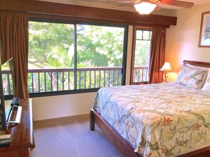A bedroom with a large window, a bed, a nightstand, a lamp, and a ceiling fan. - Wailea Custom Home, Pool, Panoramic Ocean View, Waterfalls - Maui Ocean Palms (Kihei)