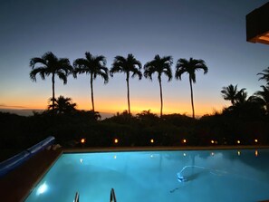 A swimming pool with a view of palm trees and a sunset. - Wailea Custom Home, Pool, Panoramic Ocean View, Waterfalls - Maui Ocean Palms (Kihei)