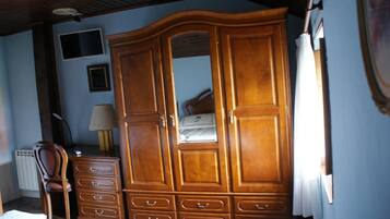 Un dormitorio con un armario de madera, un escritorio y una silla.