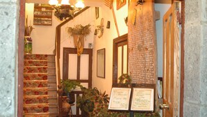A staircase with floral patterned steps, a wooden door, and a sign with menu prices. - Posada el Mirador (Soba)