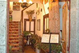 Una escalera con peldaños de estampado floral, una puerta de madera y un cartel con precios del menú.