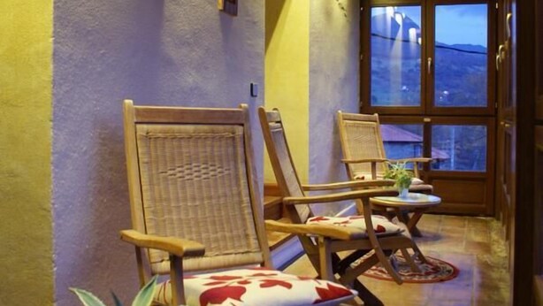 A cozy lounge area with wicker chairs and a small table with a potted plant. - Posada el Mirador (Soba)