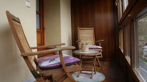 A corner room with two wooden chairs, one with a cushion and a small table with a plant. - Posada el Mirador (Soba)