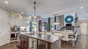 A spacious kitchen with a central island, stainless steel appliances, and a chandelier. - Executive Retreats, Family Reunions, Near Montaluce, 8 King Beds  (Dahlonega)