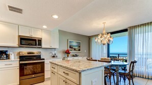 A modern kitchen with white cabinets, a stainless steel oven, and a granite countertop. - Beautiful Oceanfront, 3br/2ba Beachwalker (Amelia Island)