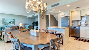 A modern kitchen with a central island, stainless steel appliances, and a chandelier. - Beautiful Oceanfront, 3br/2ba Beachwalker (Amelia Island)