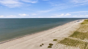 A beach with a clear sky and calm sea.