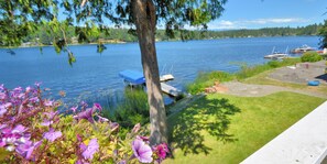 A lakeside view with boats docked, a grassy area, and a tree. - Lakefront Home-4 Bedrooms, 3 Full Bathrooms-Sleeps 10+ Hot Tub and Kayaks  (Bremerton)
