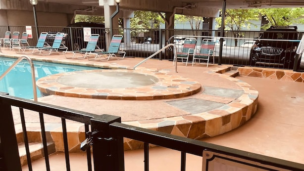 A pool area with lounge chairs and a hot tub. - Downtown, nice furnishings, clean and cozy w/ fireplace, indoor & outdoor pools. (Gatlinburg)