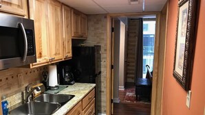 A kitchen with wooden cabinets, a stainless steel microwave, and a stove. - Downtown, nice furnishings, clean and cozy w/ fireplace, indoor & outdoor pools. (Gatlinburg)