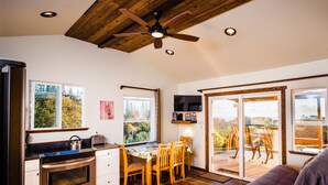 Une cuisine moderne avec un plancher en bois, un four encastré et un coin repas comprenant une table et des chaises.