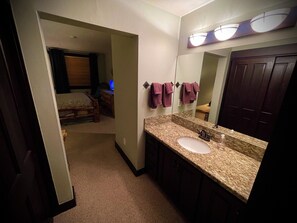 2 habitaciones, escritorio y tabla de planchar con plancha