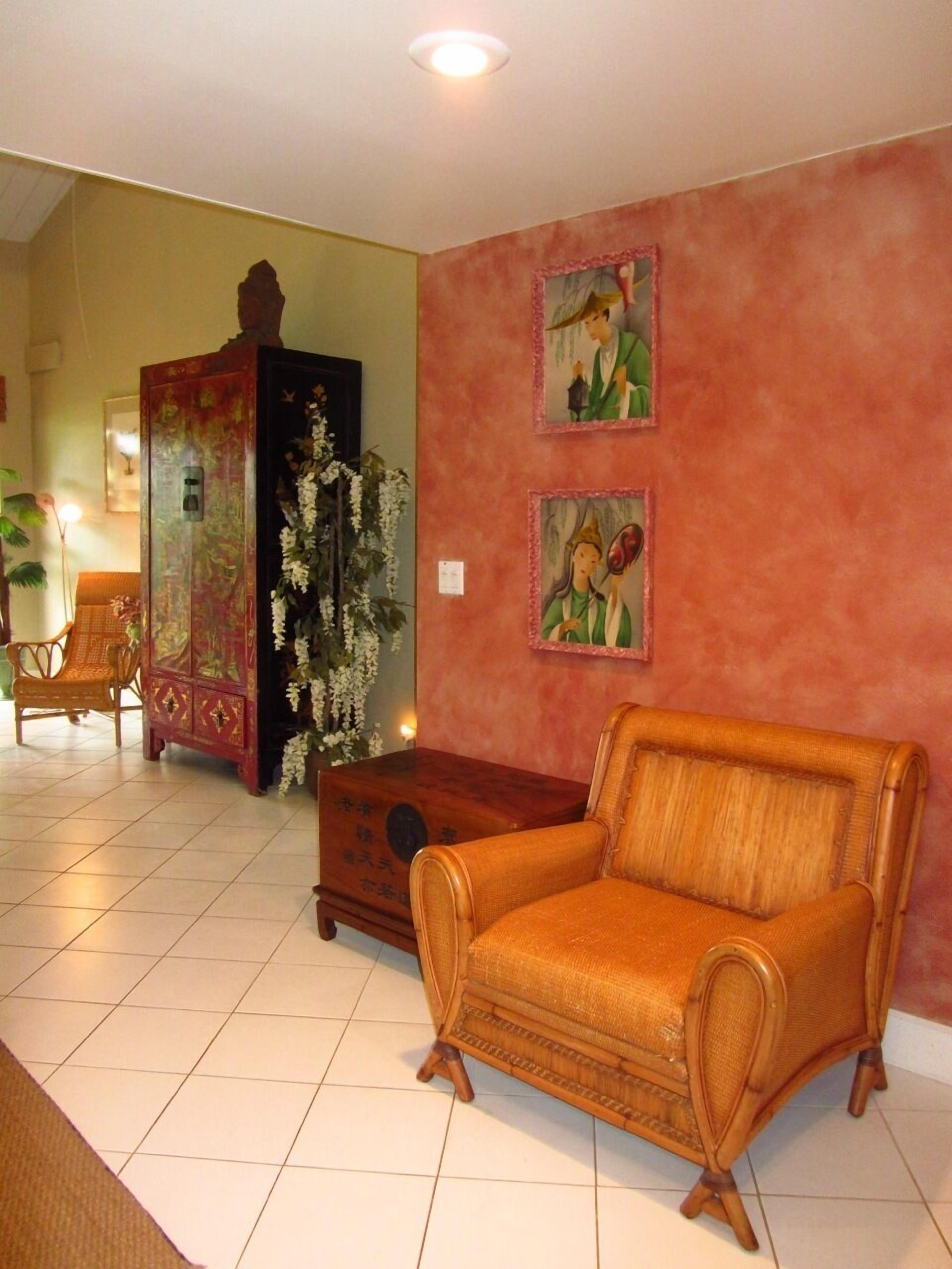 Una sala de estar con un sofá tradicional, un aparador y dos cuadros enmarcados en la pared.