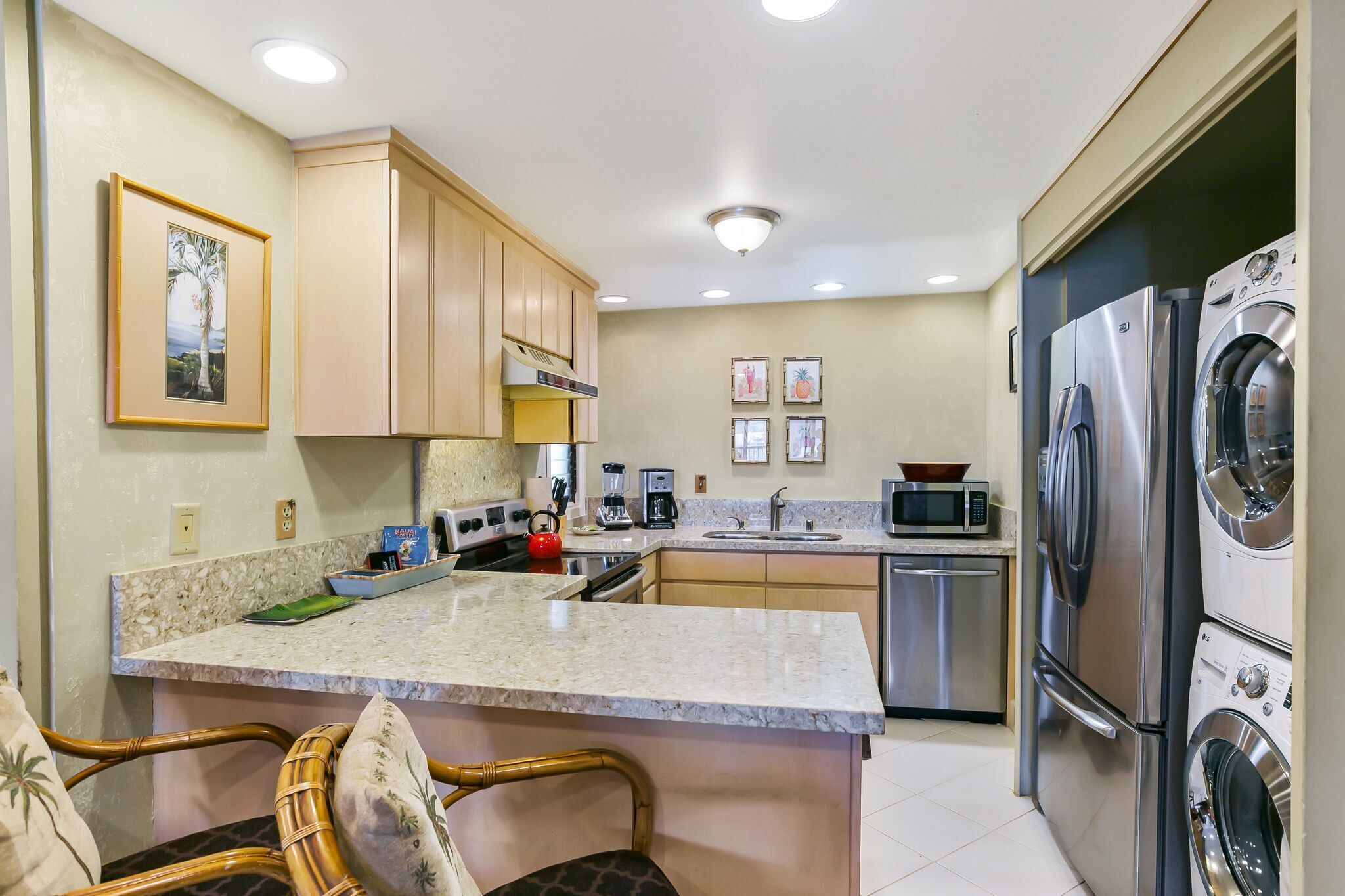 A kitchen with wooden cabinets, a granite countertop, a built-in oven, a microwave, a coffee maker, and a dishwasher.