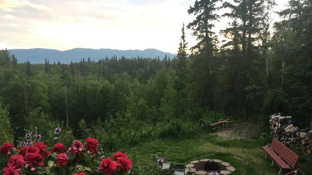 A garden with red flowers, a fire pit, and a wooden bench. - Mountain Vista Retreat, Excellent Views, Private entrance and living area (Palmer)