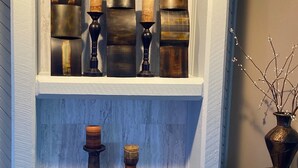 Una estantería decorativa con velas y un florero.
