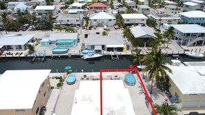 A marina with boats docked, a swimming pool, and a red outlined area. - Ocean Side Canal Half Duplex, 37' Dock, 600' To Channel With Pool (Marathon)