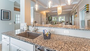 A kitchen with granite countertops, a stainless steel sink, and pendant lighting. - 117 Heated Pool | Elevator | Kids Retreat | Sleeps Big Families | Pet Friendly (Hilton Head Island)