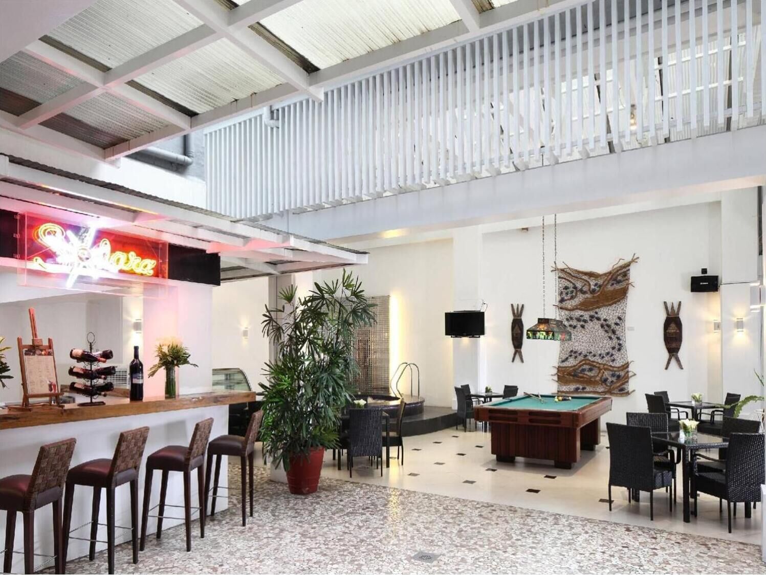 A spacious lobby with a pool table, bar area, and seating.