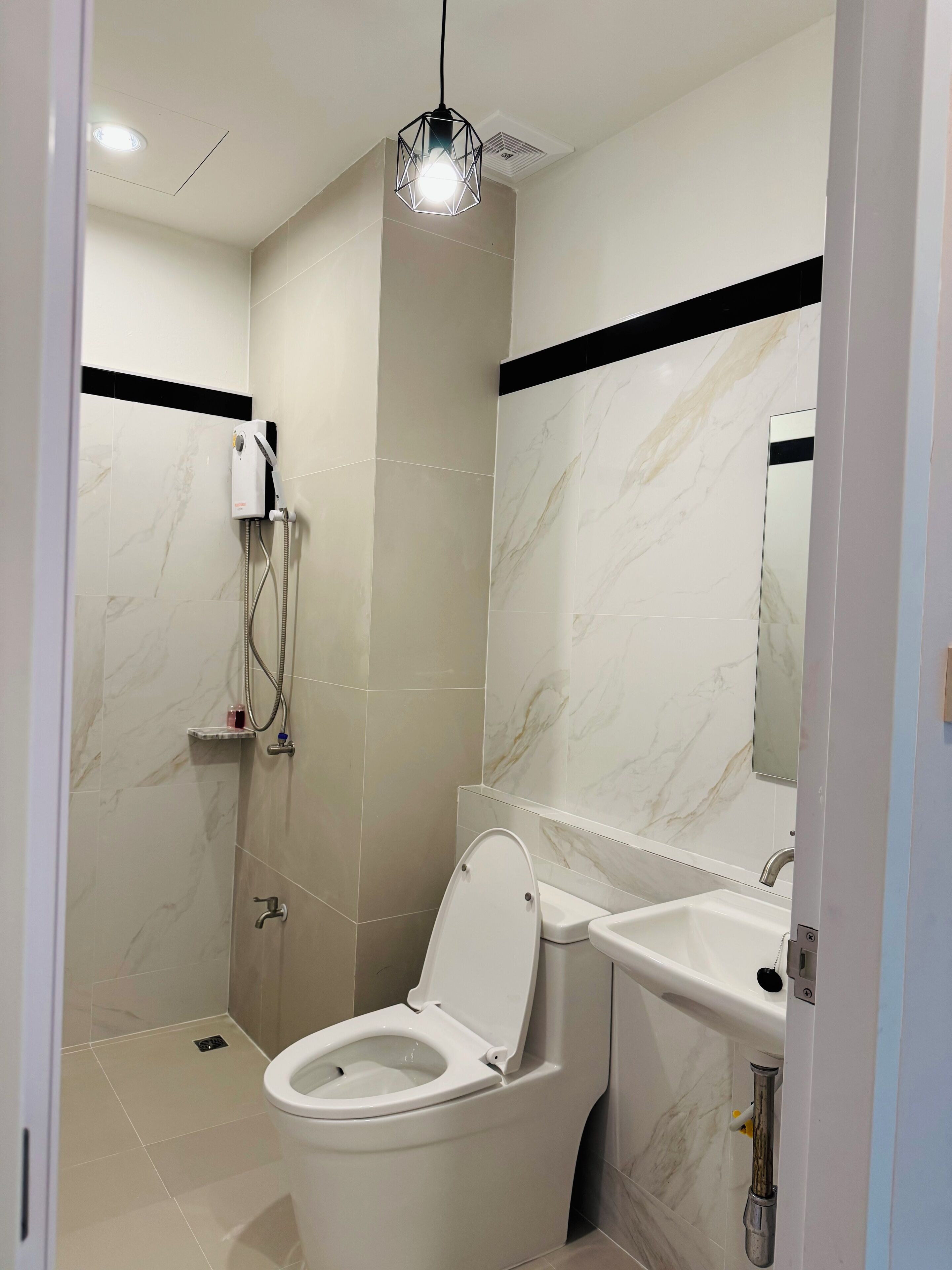 A modern bathroom with a toilet, sink, and shower.