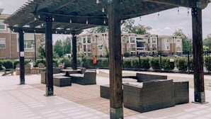 A covered outdoor seating area with benches and a pergola structure.