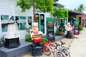 A building with a 'Welcome' sign, a windmill, and a bicycle. - Yenta Resort (Chumphon)