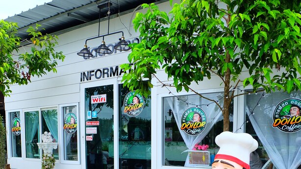 A building with a sign that reads "INFORMATION" and a large statue of a chef giving a thumbs-up. - Yenta Resort (Chumphon)