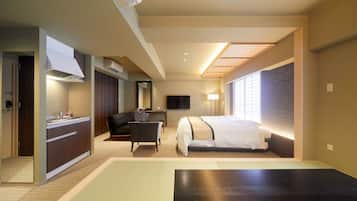 A hotel room with a bed, a desk, a chair, a TV, and a window with blinds.