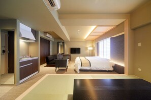 Una habitación de hotel con cama, escritorio, silla, televisor y ventana con persianas.