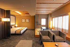 Una habitación de hotel con una cama, un sofá, una mesa y vistas al exterior por una ventana.