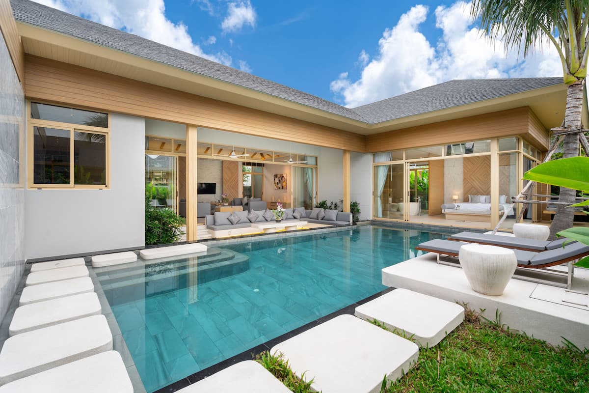 A modern house with a swimming pool, outdoor seating, and a patio area.