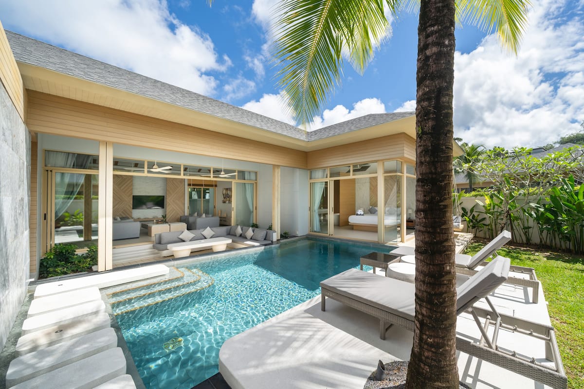 A modern house with a swimming pool, large windows, and a well-maintained garden.