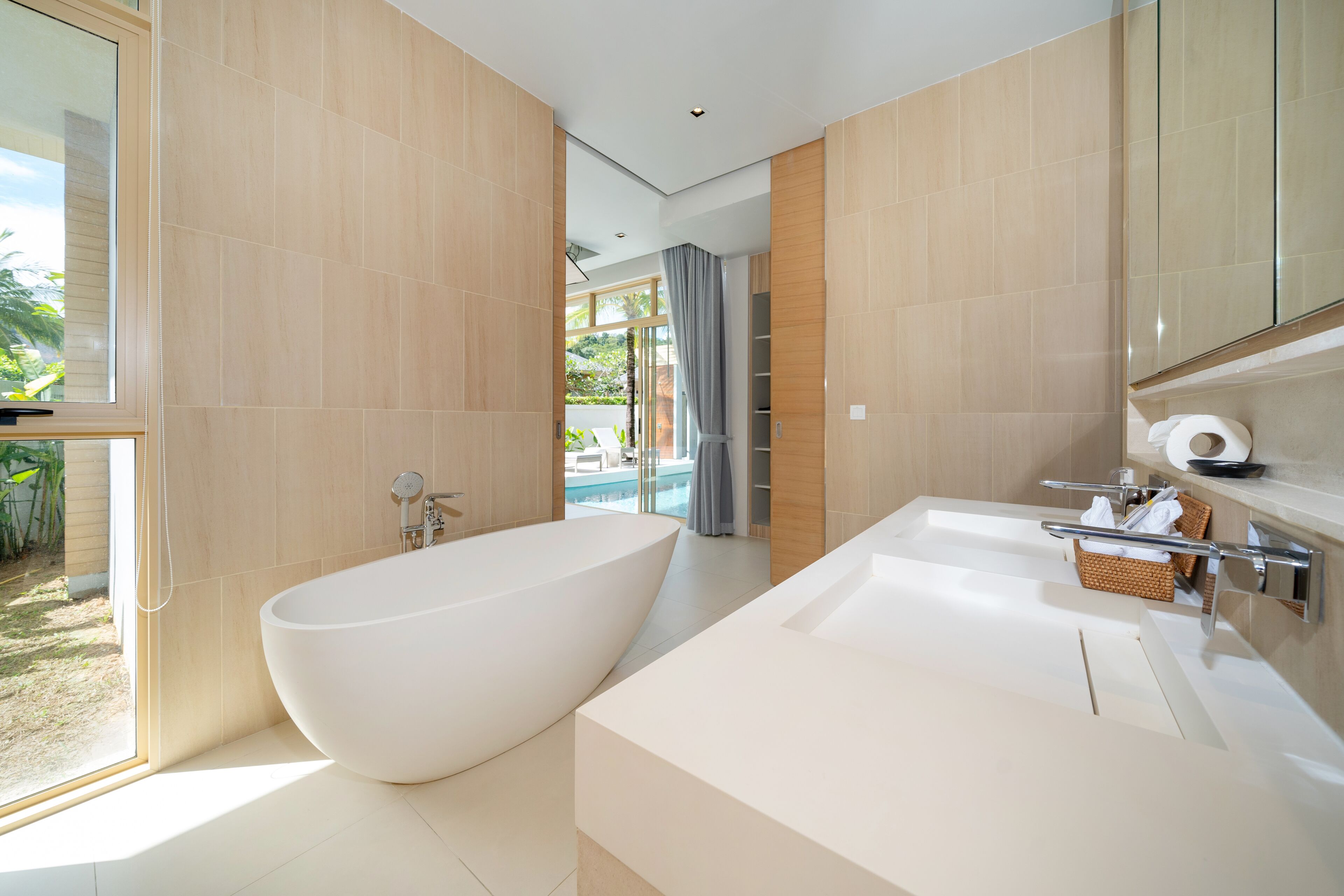 A modern bathroom with a freestanding bathtub, a large sink, and a glass shower enclosure.