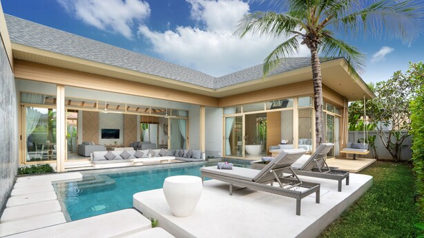 A modern house with a pool, outdoor seating, and a well-maintained lawn.