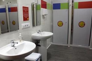 A bathroom with two sinks, a mirror, and a shower area. - Summer Hostel Cádiz (Cádiz)