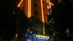 A building with illuminated vertical lines and a sign indicating it is the EverBlooming Hotel. - Jiulongwan Boutique Apartment (Zhuhai)