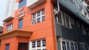 A multi-story building with a prominent orange facade and a sign with Chinese characters. - A2 Suites (Lagos)