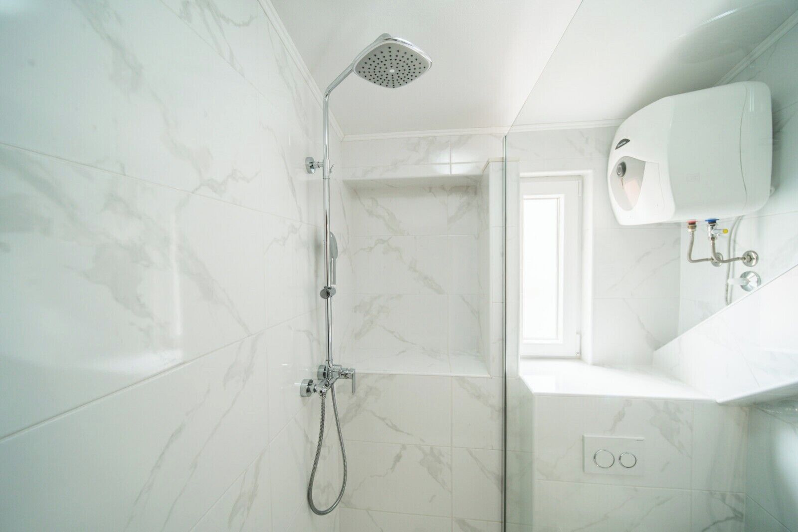 A modern bathroom with a shower, a sink, and a mirror.