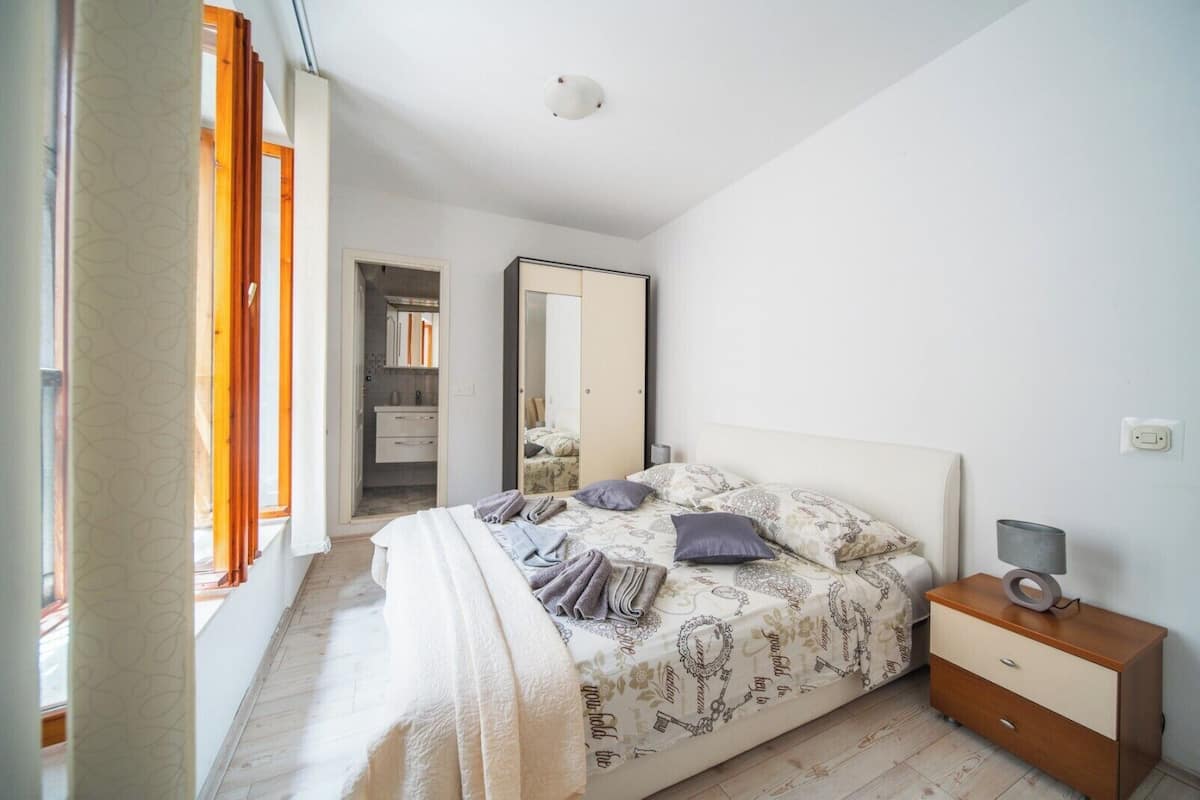 A bedroom with a bed, bedside table, and a wardrobe.
