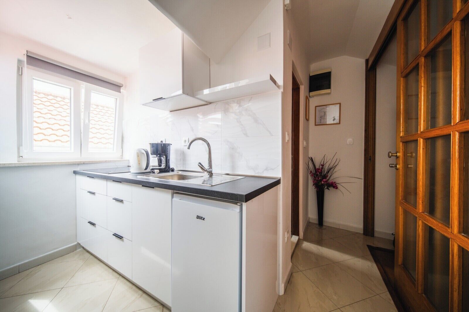 A compact kitchen with a sink, stove, and cabinets.