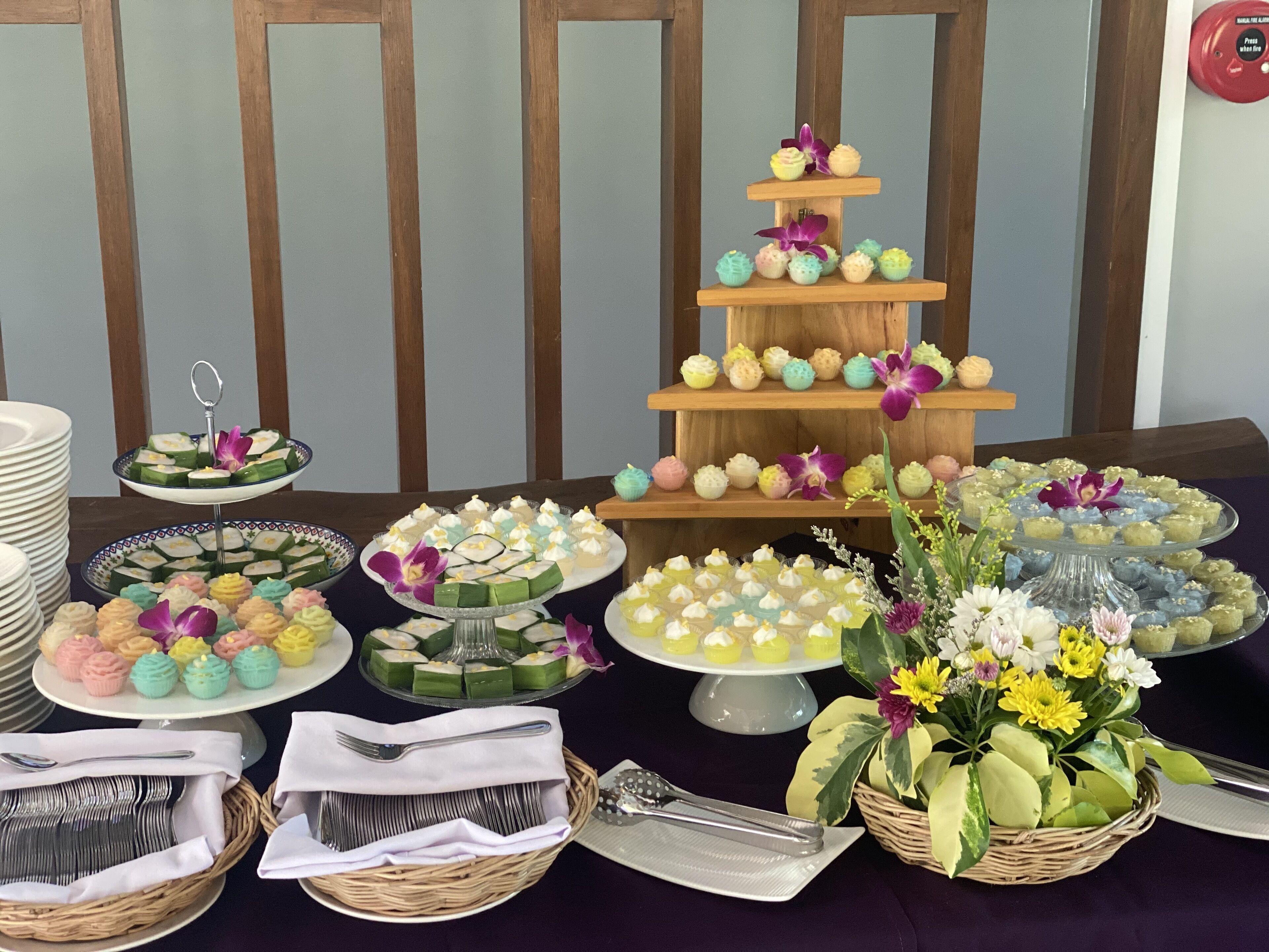 Une table de buffet proposant divers desserts et un présentoir à gâteaux à plusieurs étages.