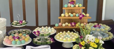 Une table de buffet proposant divers desserts et un présentoir à gâteaux à plusieurs étages.