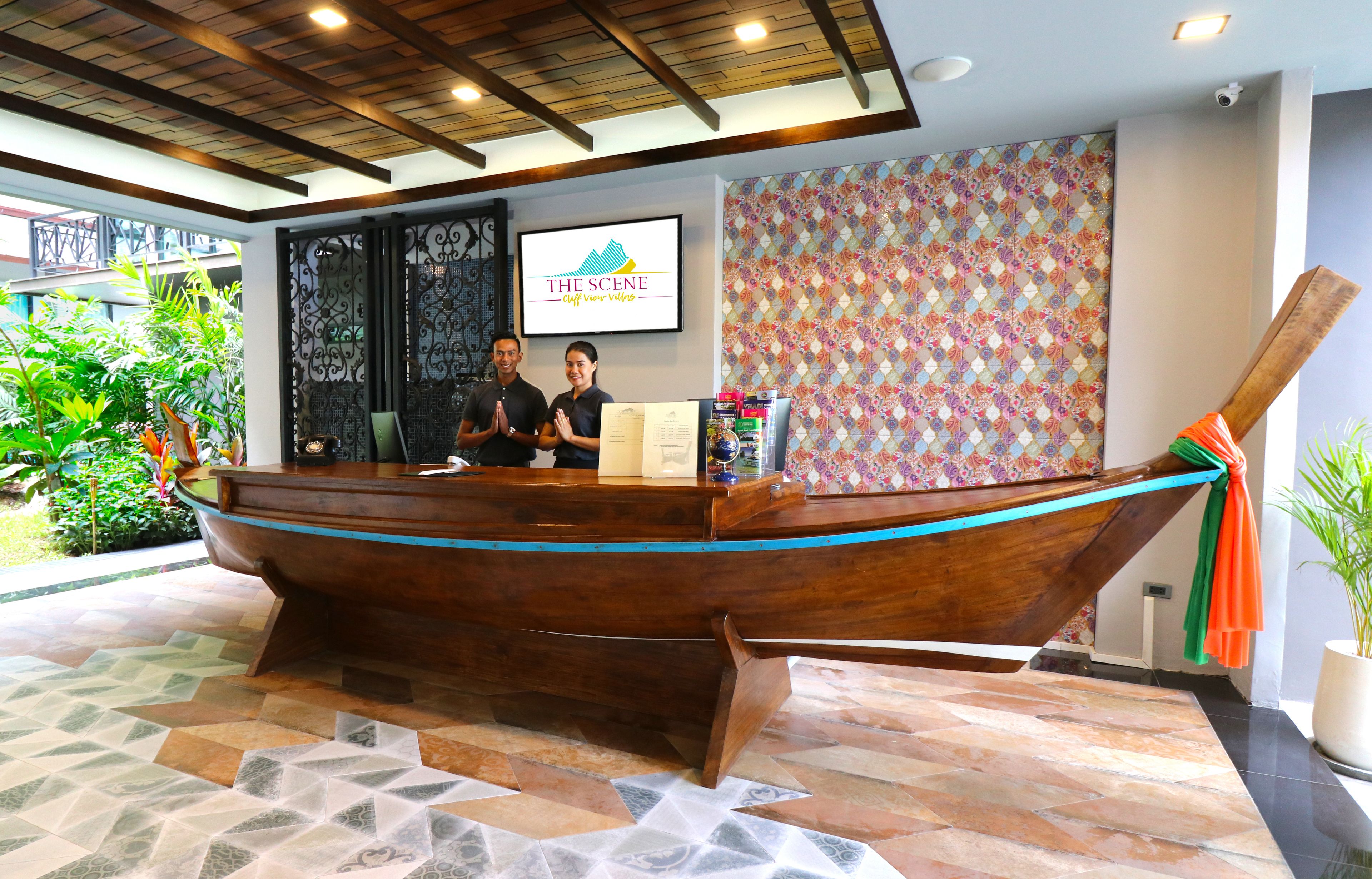 Un comptoir d’accueil conçu comme un bateau en bois, un logo encadré accroché au mur et un mur décoré d’un motif.