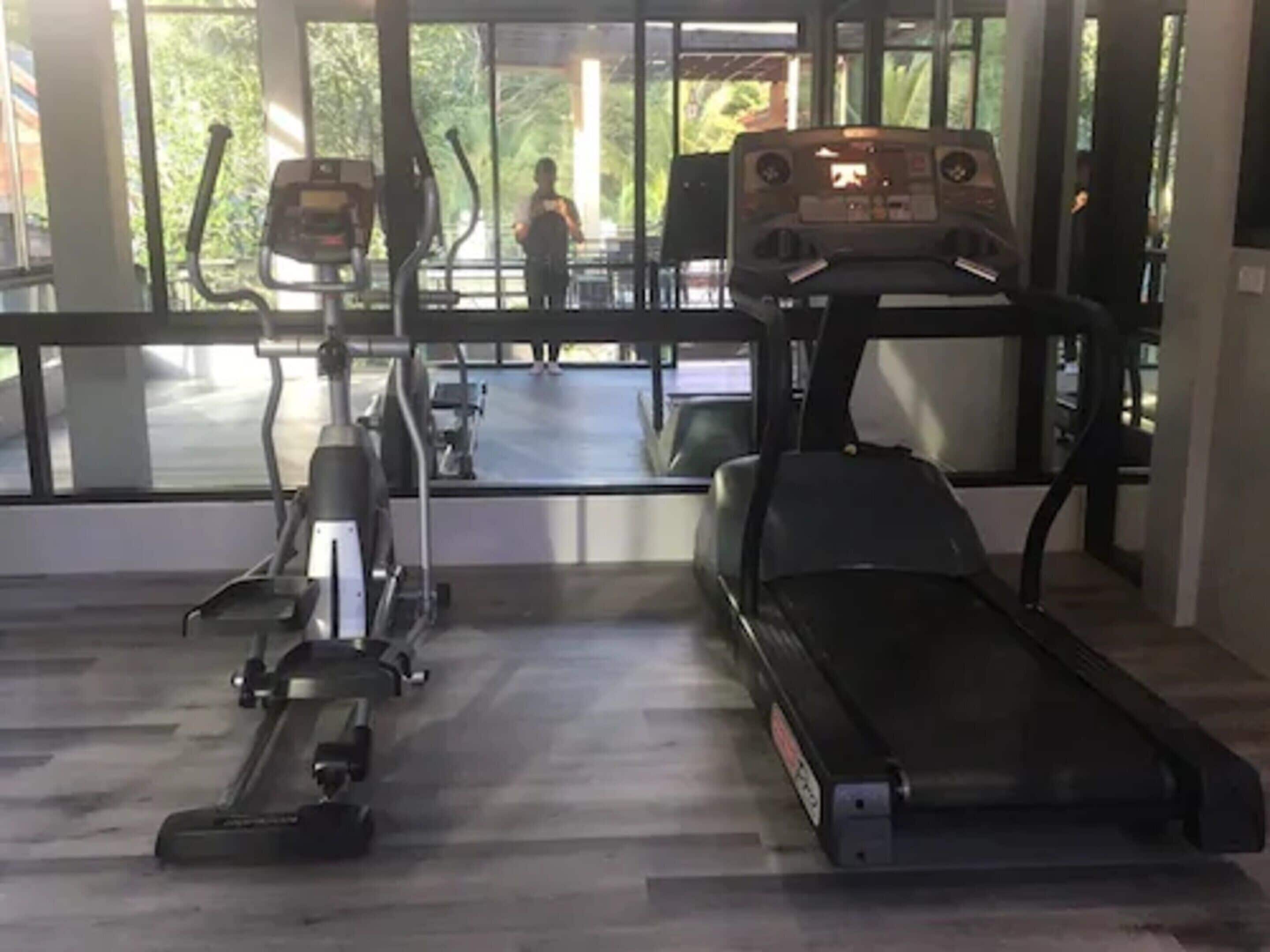 A gym with cardio equipment, including a treadmill and an elliptical machine.