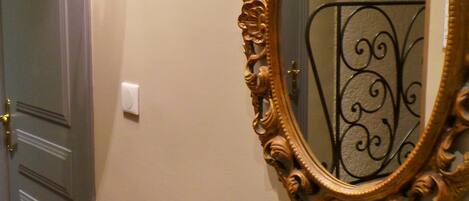 A hallway with a door, a wall-mounted mirror, and a console table.