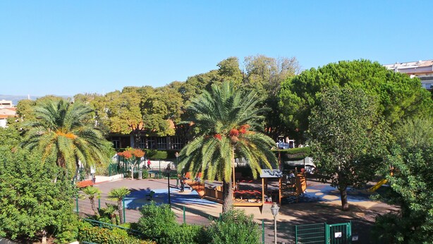A park with palm trees, a playground, and a gazebo. - Hotel Le Relais Du Postillon (Antibes)
