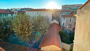 A courtyard with a tiled roof, surrounded by buildings with balconies and windows. - Hotel Le Relais Du Postillon (Antibes)