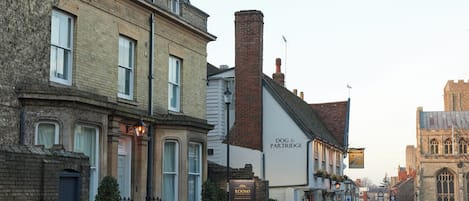 A street view with a pub named "Dog & Partridge" and a church in the background.